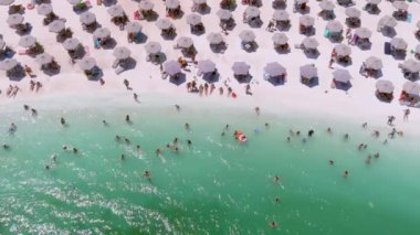 Mermer plaj, Thassos adası, Yunanistan - 19 Temmuz 2021: Yukarıdan bakıldığında, plaj şemsiyeleri ve yüzen ve dinlenen turistlerle dolu beyaz plajlı bir zümrüt ve saydam Akdeniz manzarası.