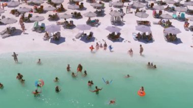 Mermer plaj, Thassos adası, Yunanistan - 19 Temmuz 2021: Yukarıdan bakıldığında, plaj şemsiyeleri ve yüzen ve dinlenen turistlerle dolu beyaz plajlı bir zümrüt ve saydam Akdeniz manzarası.
