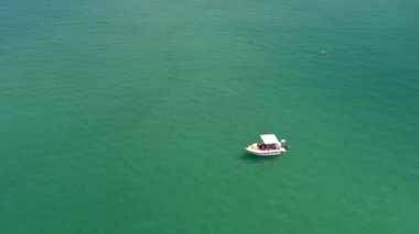 Yukarıdan bakıldığında, Yunan Thassos adasında tropik zümrüt açık denizde yüzen küçük bir geminin havadan görünüşü. Psili Ammos, Thassos Adası, Yunanistan - 17 Temmuz 2021