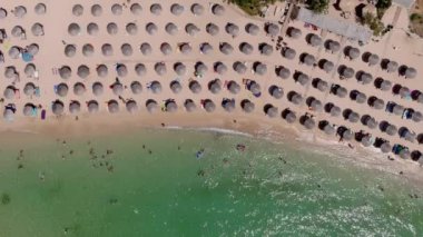 Yukarıdan bakıldığında, zümrüt ve şeffaf bir Akdeniz manzarası, plaj şemsiyeleri ve dinlenip yüzen turistlerle dolu beyaz bir plaj. Psili Ammos, Thassos Adası, Yunanistan - 17 Temmuz 2021