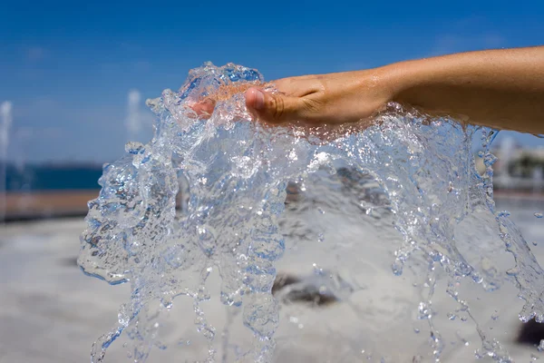 Mains de femme avec éclaboussure d'eau — Photo