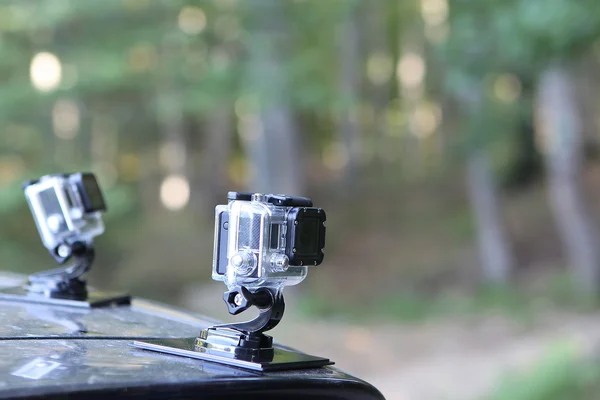 Gopro Hero 3 Cameras on the hood of a car in nature. Gopro went — Stock Photo, Image