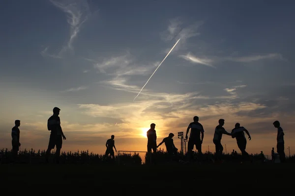 Silhouetten van voetballers op het avondrood — Stockfoto