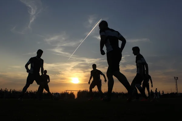 Siluetas de futbolistas en el cielo del atardecer — Foto de Stock