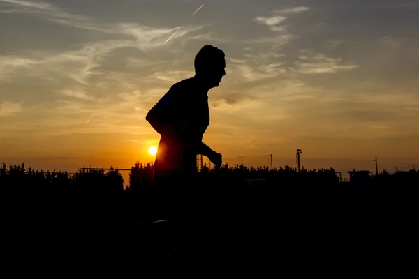 Siluetas del hombre corriendo al atardecer — Foto de Stock