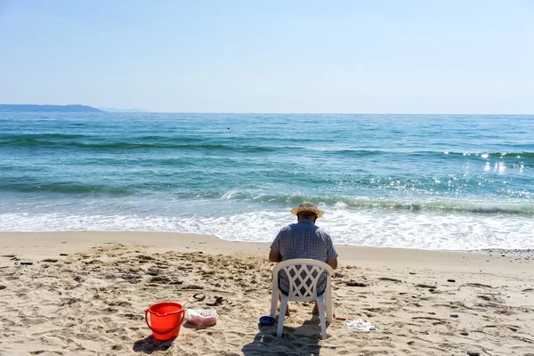 Vista trasera de senior mirando sobre el mar en la playa — Foto de Stock