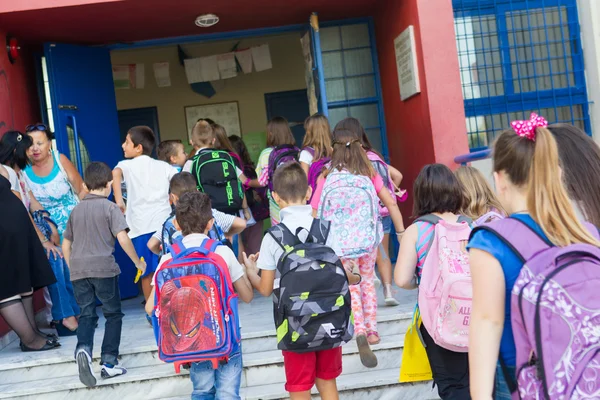 Estudiantes con sus mochilas entrando en la escuela. Primer día de —  Fotos de Stock