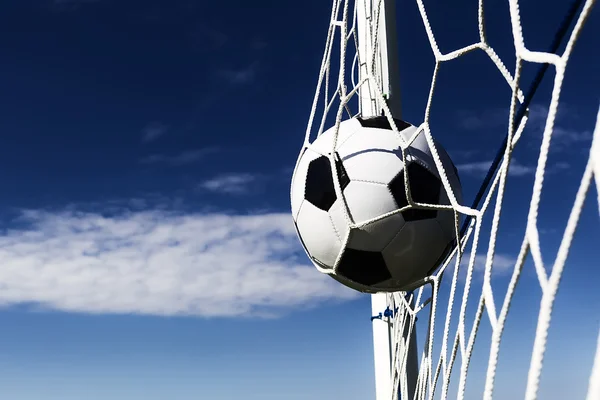 Fútbol de fútbol en Goal net con campo de cielo. Contraste oscuro — Foto de Stock