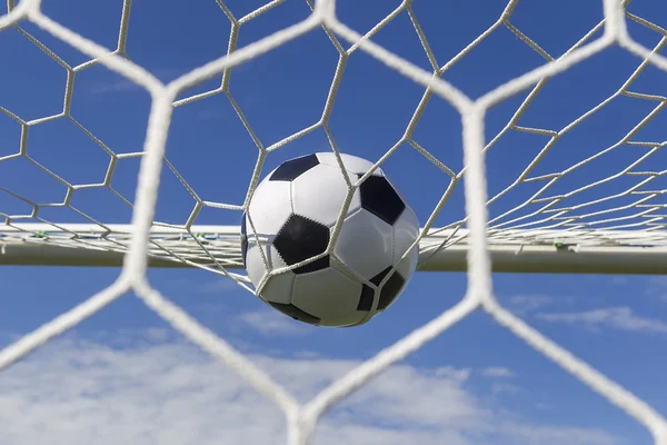 Voetbal voetbal in doel netto met sky veld. — Stockfoto