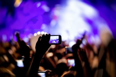 Bir müzik sırasında dokunmatik akıllı telefon ile fotoğraf çekmeye kişi 