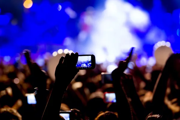 Pessoas tirando fotos com telefone inteligente de toque durante uma música — Fotografia de Stock