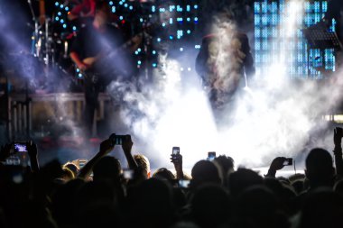 Bir müzik sırasında dokunmatik akıllı telefon ile fotoğraf çekmeye kişi 
