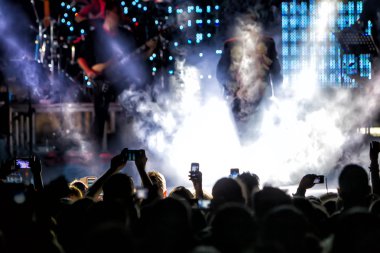 Bir müzik sırasında dokunmatik akıllı telefon ile fotoğraf çekmeye kişi 