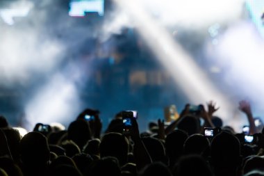 Bir müzik sırasında dokunmatik akıllı telefon ile fotoğraf çekmeye kişi 