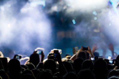 Bir müzik sırasında dokunmatik akıllı telefon ile fotoğraf çekmeye kişi 