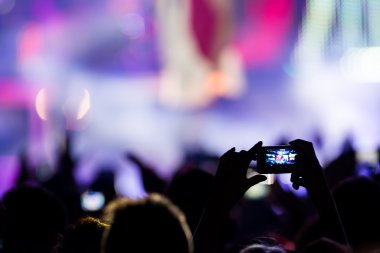 Bir müzik sırasında dokunmatik akıllı telefon ile fotoğraf çekmeye kişi 
