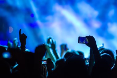Bir müzik sırasında dokunmatik akıllı telefon ile fotoğraf çekmeye kişi 