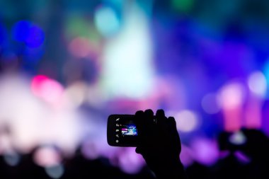 Bir müzik sırasında dokunmatik akıllı telefon ile fotoğraf çekmeye kişi 