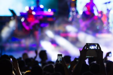 Bir müzik sırasında dokunmatik akıllı telefon ile fotoğraf çekmeye kişi 