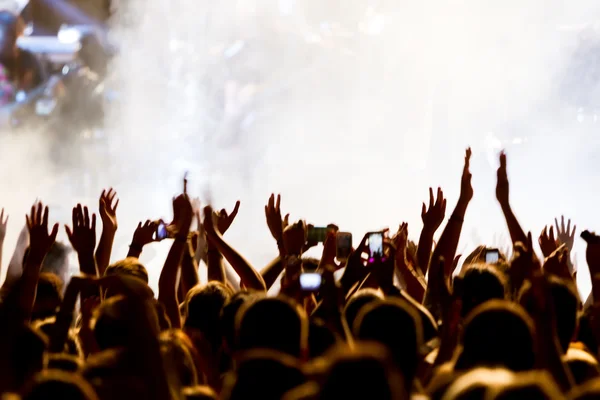 Personas que toman fotografías con un teléfono inteligente táctil durante una música — Foto de Stock