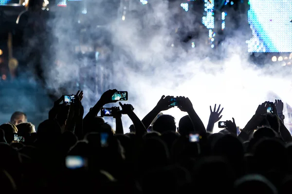 People taking photographs with touch smart phone during a music