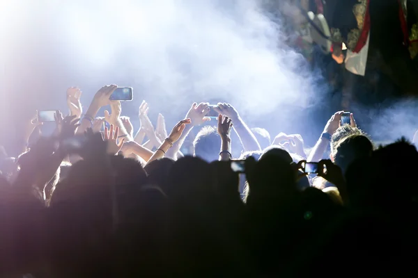 Personas que toman fotografías con un teléfono inteligente táctil durante una música — Foto de Stock