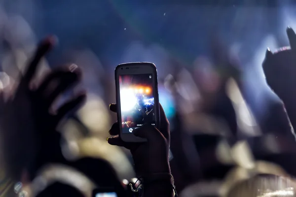 Pessoas tirando fotos com telefone inteligente de toque durante uma música — Fotografia de Stock