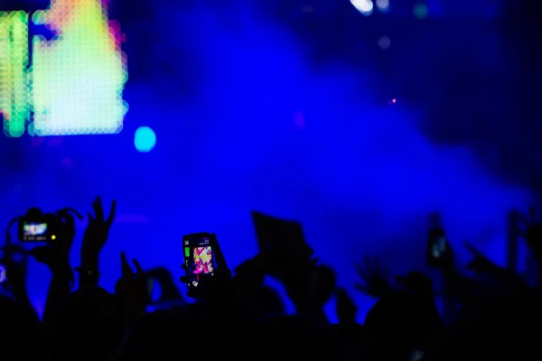 Personas que toman fotografías con un teléfono inteligente táctil durante una música —  Fotos de Stock