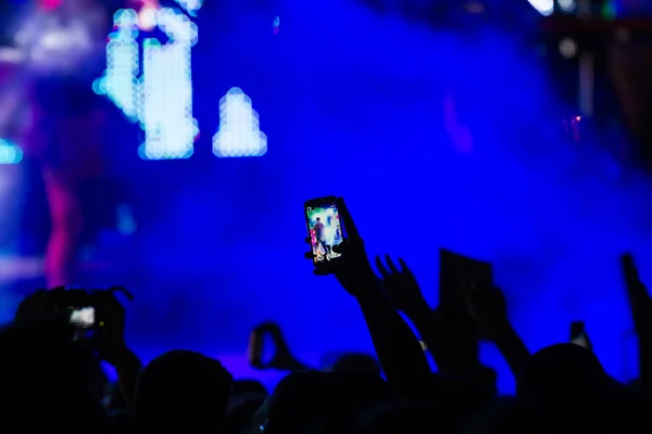 Pessoas tirando fotos com telefone inteligente de toque durante uma música — Fotografia de Stock
