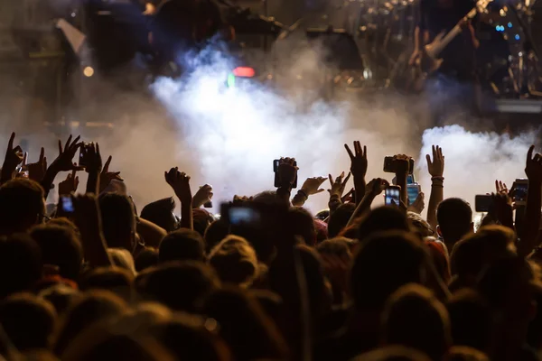 Personas que toman fotografías con un teléfono inteligente táctil durante una música — Foto de Stock