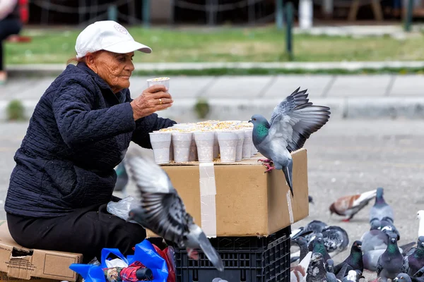 Mujer vendiendo semillas para alimentar a las palomas en la famosa plaza Ari —  Fotos de Stock