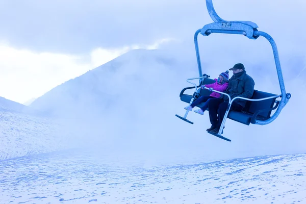Sciatori non identificati salendo con uno skilift e godendo la — Foto Stock