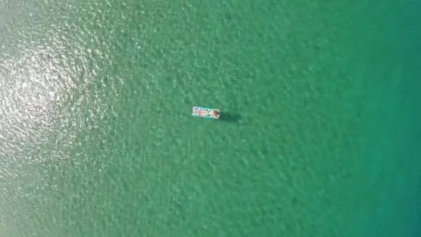 Vrouw ontspannen op opblaasbare matras op het strand — Stockvideo