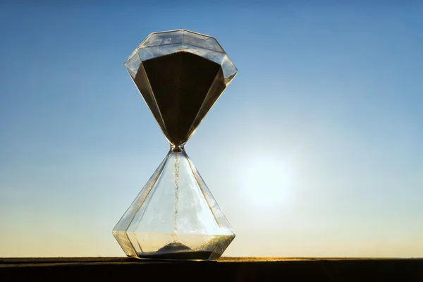 Hourglass on a background sunset — Stock Photo, Image