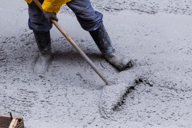 Kaldırımın yükseltilmesi sırasında çimento dökülüyor
