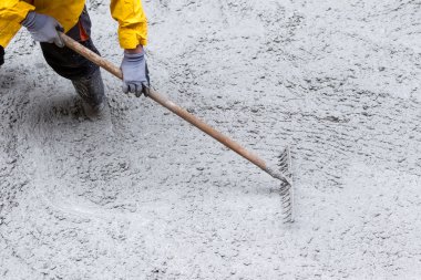 Kaldırımın yükseltilmesi sırasında çimento dökülüyor