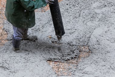 Kaldırımın yükseltilmesi sırasında çimento dökülüyor