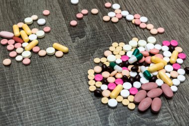 Ahşap arka plan üzerinde birçok renkli hapları.