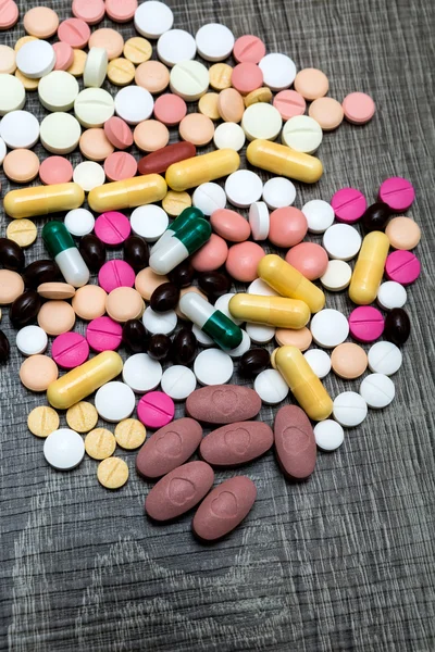Veel kleurrijke pillen op een houten achtergrond. — Stockfoto