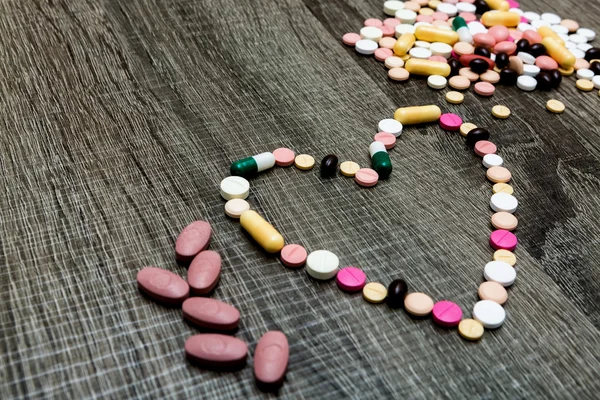 Pílulas coloridas na forma do coração — Fotografia de Stock