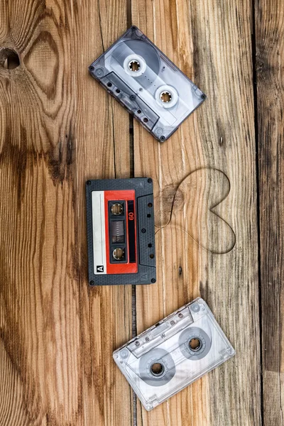 Vintage audio cassette with loose tape shaping two hearts on a w — Stock Photo, Image