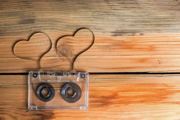 Vintage audio cassette with loose tape shaping two hearts on a w — Stock Photo, Image