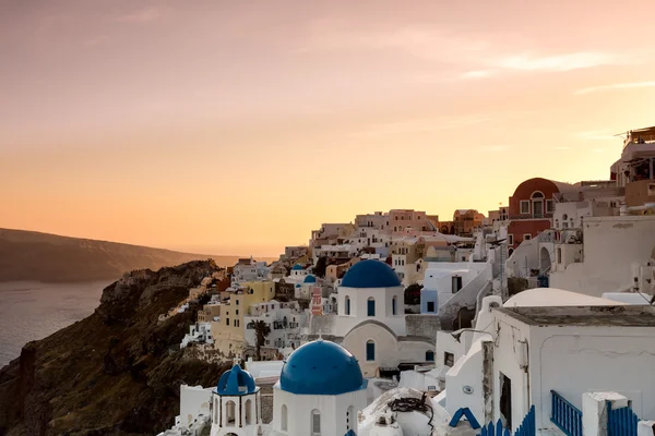 O pôr do sol na aldeia de Oia, na ilha de Santorini, na Grécia — Fotografia de Stock