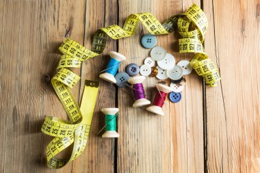 Ahşap arka plan üzerinde iğneler iş parçacığıyla makaralar. Eski dikiş bir