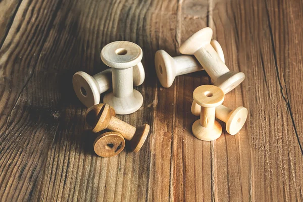 Empty wooden sewing spools on old wood background — Stock Photo, Image