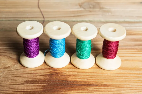 Spools of thread on wooden  background. Old sewing accessories. — Stock Photo, Image