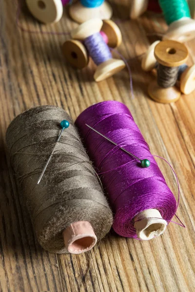 Spools of thread on wooden  background. Old sewing accessories. — Stock Photo, Image