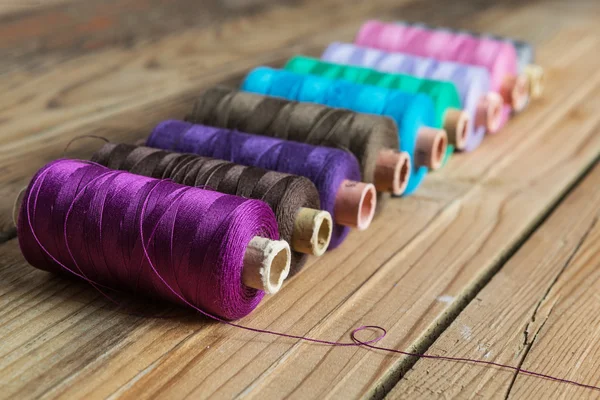 Bobinas de hilo sobre fondo de madera. Accesorios de costura antiguos . — Foto de Stock