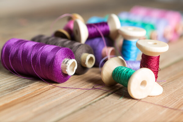 Spools of thread on wooden  background. Old sewing accessories. 