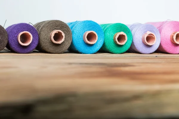 Spools of thread on wooden  background. Old sewing accessories. — Stock Photo, Image